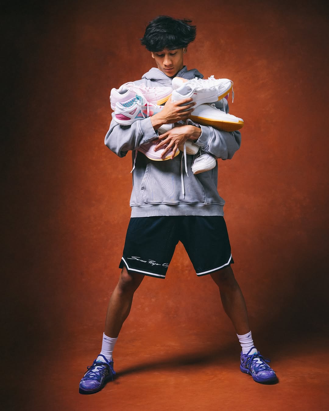 Joueur de basketball avec pleins de chaussures de basket dans les mains